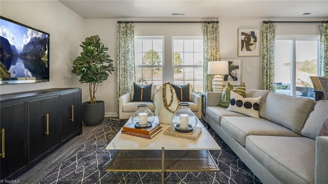 living room featuring a healthy amount of sunlight and dark hardwood / wood-style flooring