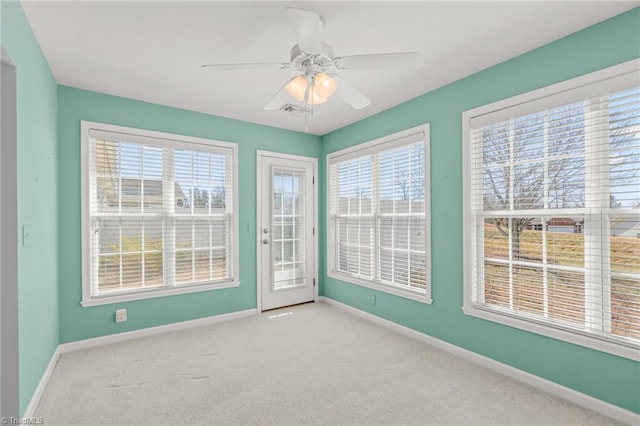 carpeted spare room with baseboards and ceiling fan