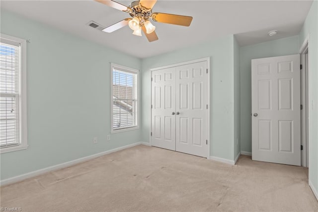 unfurnished bedroom with visible vents, a ceiling fan, a closet, carpet flooring, and baseboards