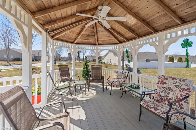 wooden terrace featuring fence, a yard, ceiling fan, a gazebo, and a residential view