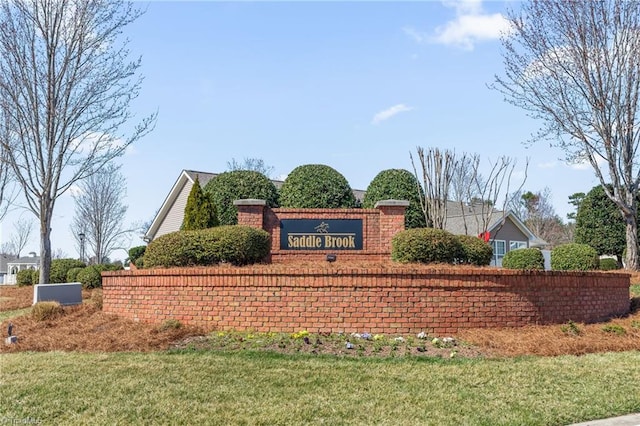 community sign featuring a yard