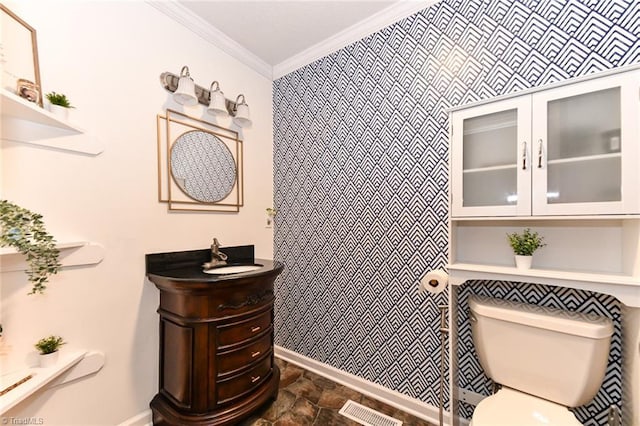 bathroom featuring toilet, vanity, and ornamental molding