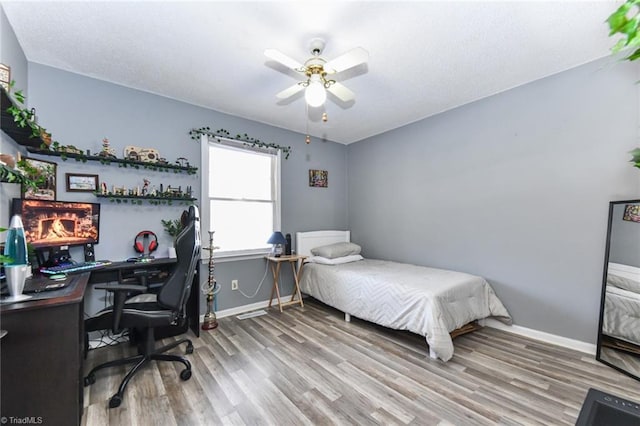 bedroom with ceiling fan and hardwood / wood-style floors