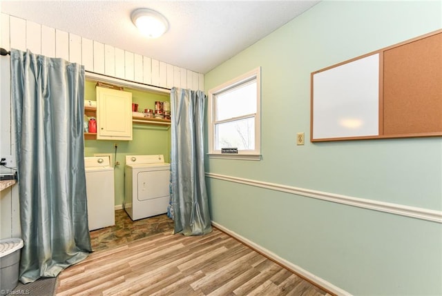 laundry room with light hardwood / wood-style floors, cabinets, and washing machine and dryer