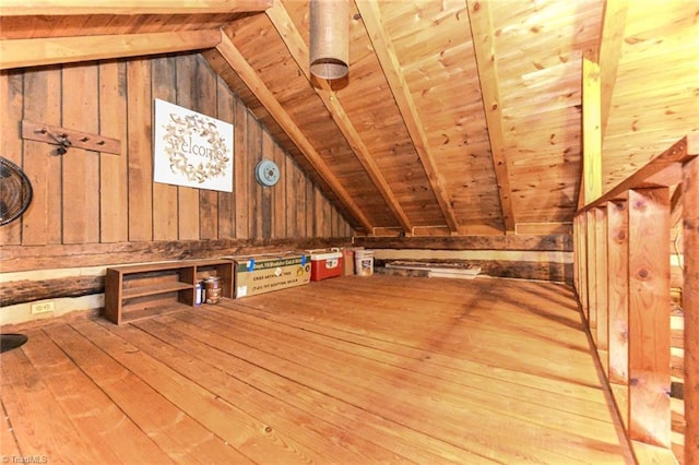 additional living space with light hardwood / wood-style flooring, wood walls, vaulted ceiling with beams, and wooden ceiling