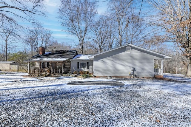 snow covered house featuring covered porch