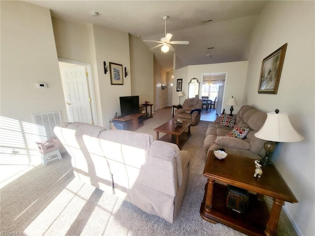 carpeted living room with ceiling fan and vaulted ceiling