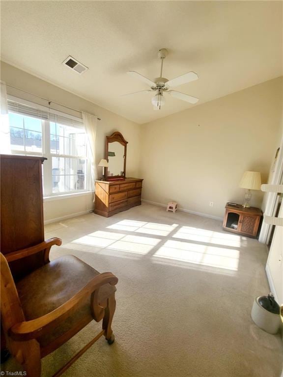 living area featuring ceiling fan and light colored carpet