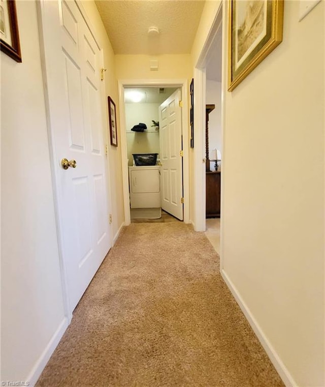 corridor featuring a textured ceiling and light colored carpet