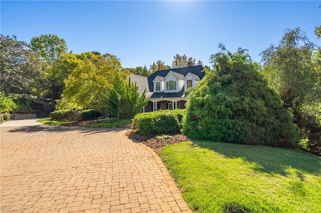 cape cod house featuring a front yard