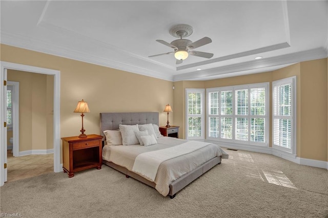 carpeted bedroom with ceiling fan, a tray ceiling, baseboards, ornamental molding, and recessed lighting