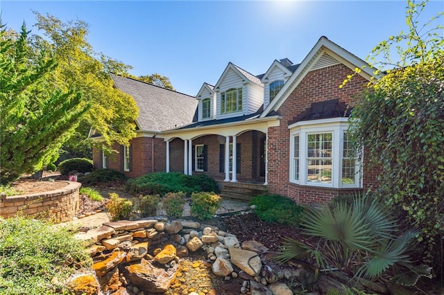 traditional-style home with a porch and brick siding