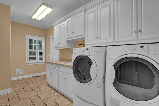 laundry area featuring cabinet space, visible vents, washing machine and clothes dryer, and baseboards