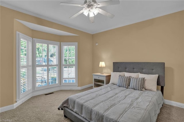 carpeted bedroom featuring a ceiling fan, baseboards, ornamental molding, and visible vents