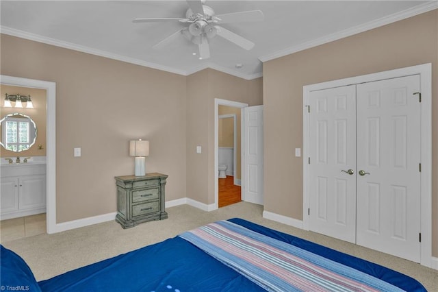 carpeted bedroom featuring ceiling fan, a closet, connected bathroom, and ornamental molding