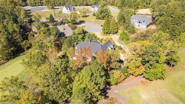 bird's eye view with a wooded view