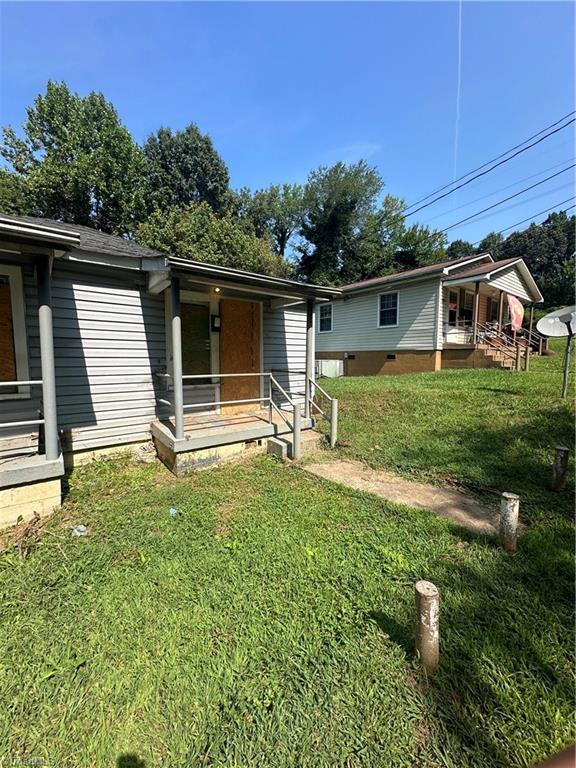 rear view of house with a lawn and covered porch