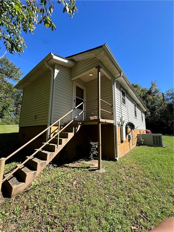 view of side of home with a yard