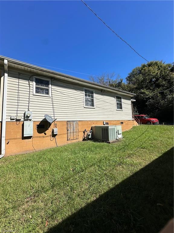 view of home's exterior featuring a yard and central AC unit