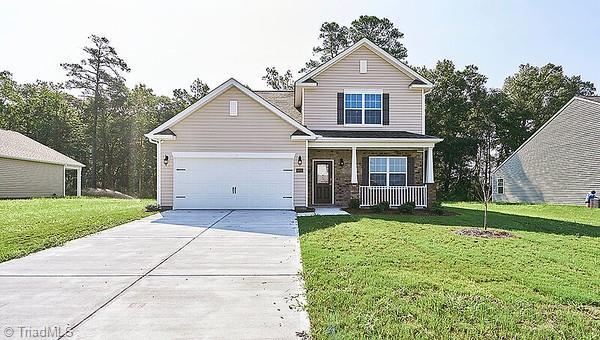 view of front of home featuring covered porch, a front yard, and a garage