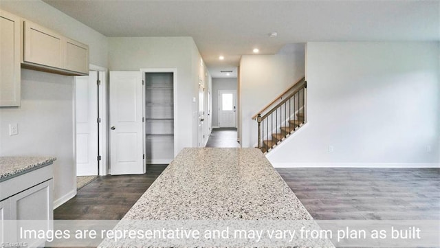 kitchen with dark wood-type flooring and light stone countertops