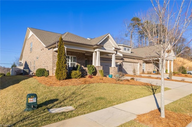 craftsman-style home with covered porch, a front yard, and a garage