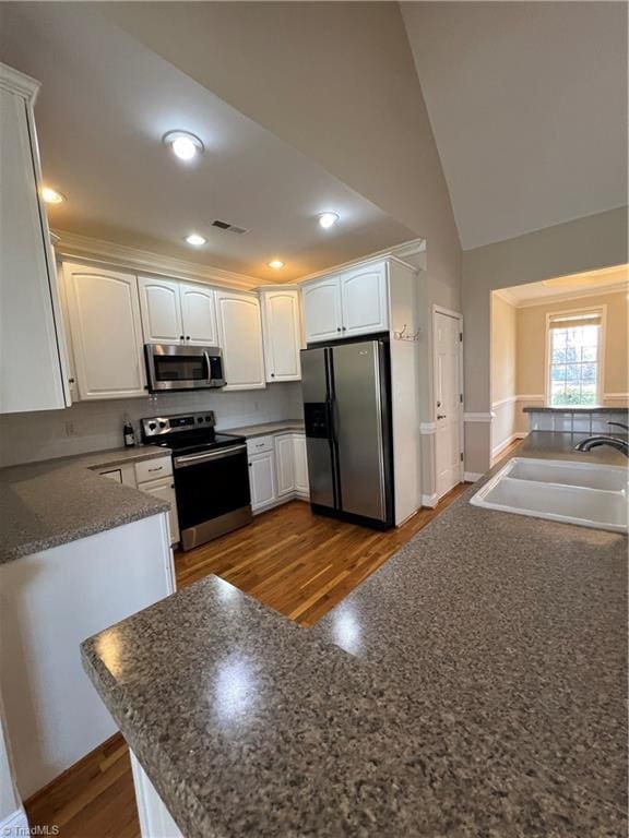 kitchen with visible vents, a sink, dark countertops, appliances with stainless steel finishes, and white cabinets