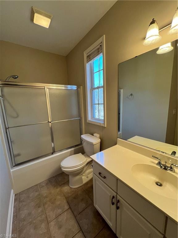 bathroom with vanity, toilet, shower / bath combination with glass door, and tile patterned flooring