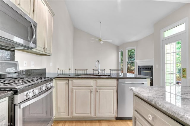 4507 Brandt Ridge Dr, Greensboro, NC 27455 - kitchen with a sink, dark stone counters, a ceiling fan, and stainless steel appliances