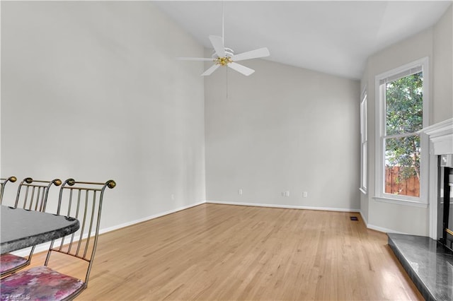 4507 Brandt Ridge Dr, Greensboro, NC 27455 - unfurnished living room featuring light wood-style floors, baseboards, a fireplace with raised hearth, and a ceiling fan