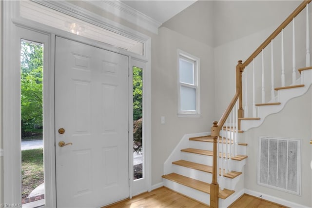 4507 Brandt Ridge Dr, Greensboro, NC 27455 - foyer featuring baseboards, wood finished floors, visible vents, ornamental molding, and stairway