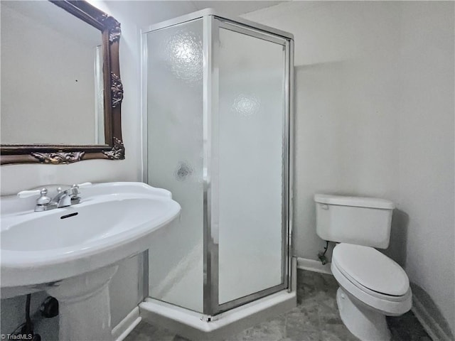 bathroom with a shower with door and toilet