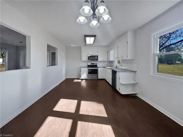 kitchen with white cabinetry, sink, a notable chandelier, stainless steel appliances, and dark wood-type flooring