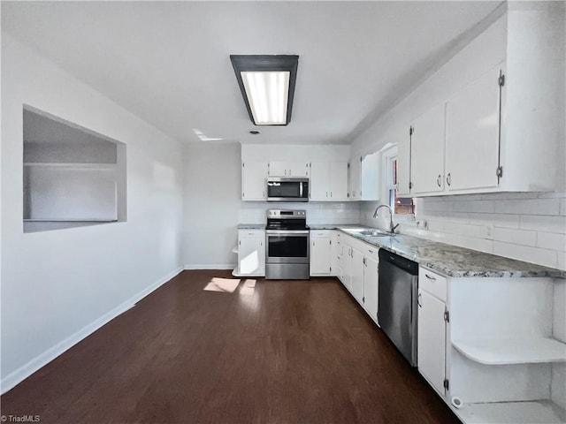 kitchen featuring appliances with stainless steel finishes, dark hardwood / wood-style floors, sink, white cabinets, and backsplash