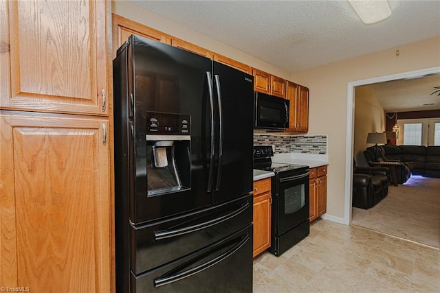 101 Kingston Ln, Graham, NC 27253 - kitchen featuring black appliances, light countertops, open floor plan, tasteful backsplash, and a textured ceiling
