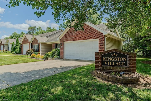 101 Kingston Ln, Graham, NC 27253 - view of front of property featuring a garage, brick siding, a front yard, and driveway