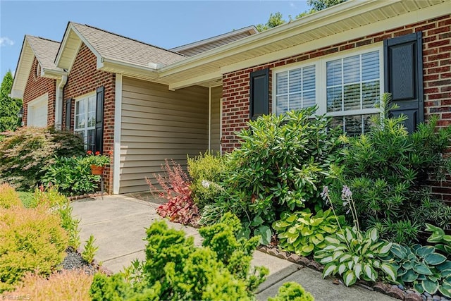 101 Kingston Ln, Graham, NC 27253 - entrance to property featuring brick siding, a shingled roof, and an attached garage