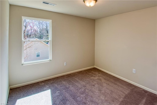 spare room with carpet, visible vents, and baseboards