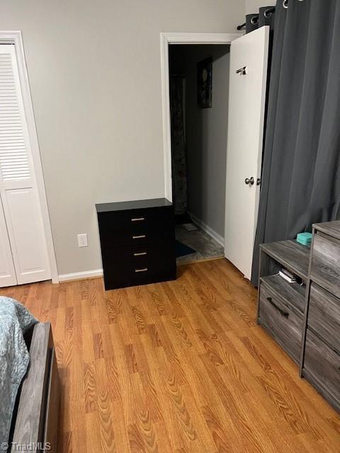 bedroom with light wood finished floors and baseboards