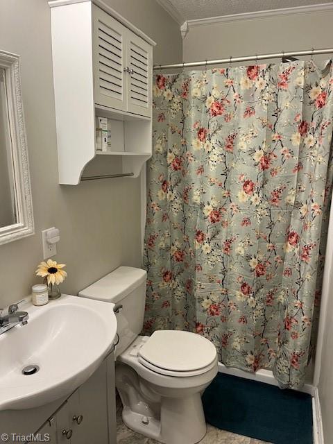 bathroom with a shower with curtain, vanity, toilet, and a textured ceiling