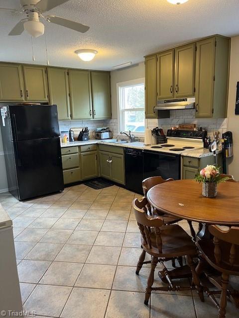 kitchen featuring light countertops, green cabinets, a sink, under cabinet range hood, and black appliances