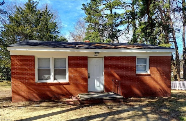 view of front of home with brick siding and fence