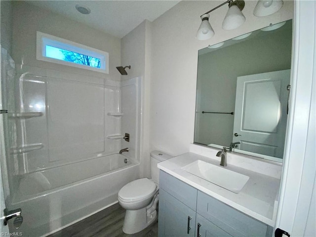 full bathroom with hardwood / wood-style flooring, shower / washtub combination, vanity, and toilet