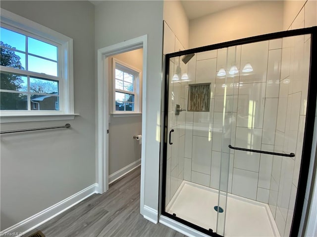 bathroom featuring a shower with shower door and hardwood / wood-style flooring