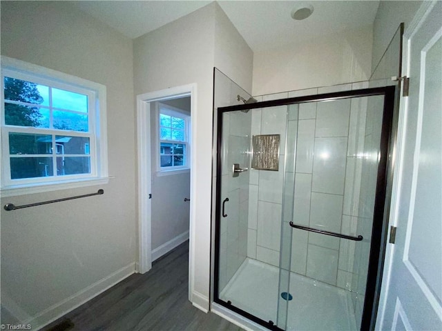 bathroom with wood-type flooring and a shower with shower door