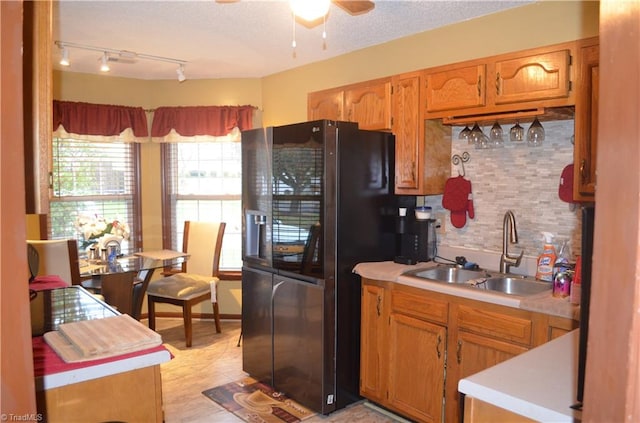 kitchen featuring sink, ceiling fan, decorative backsplash, a textured ceiling, and black fridge with ice dispenser