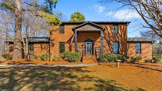 view of front facade featuring brick siding and a front lawn