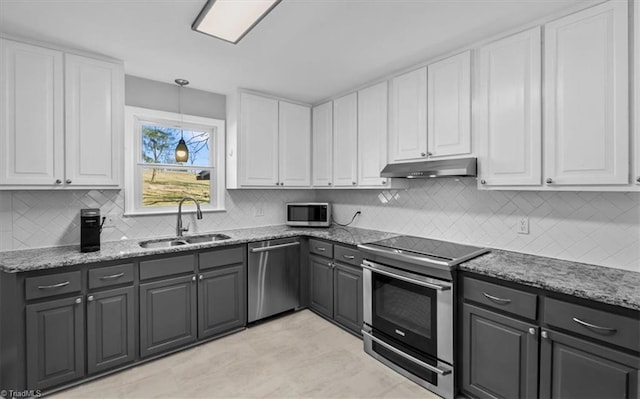 kitchen featuring appliances with stainless steel finishes, a sink, white cabinetry, and under cabinet range hood