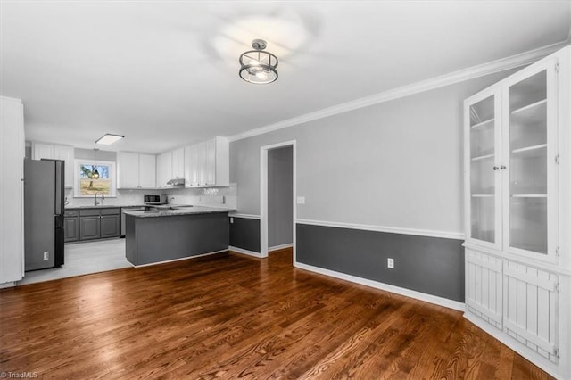 kitchen featuring gray cabinetry, stainless steel appliances, wood finished floors, white cabinetry, and crown molding