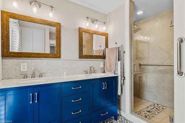 full bathroom with double vanity, a stall shower, decorative backsplash, and a sink